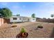 Spacious backyard with rock groundcover, small trees, and a block fence at 8524 E Mariposa Dr, Scottsdale, AZ 85251