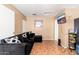 This living room is furnished with a black couch and has tile floors at 8602 N 27Th Ave, Phoenix, AZ 85051