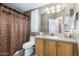 Bathroom with a single sink vanity and decorative brown shower curtain at 8840 E Sunland Ave # 137, Mesa, AZ 85208
