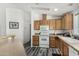 Well-lit kitchen boasts wooden cabinets, white appliances, a range hood, and modern flooring at 8840 E Sunland Ave # 137, Mesa, AZ 85208