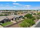 An aerial shot showcases a residential area with houses, green trees, and a clear blue sky with scattered clouds at 9147 W Minnezona Ave, Phoenix, AZ 85037