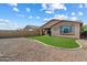 Wide backyard featuring green lawn and desert rock, enclosed by a block wall fence for privacy at 9147 W Minnezona Ave, Phoenix, AZ 85037