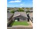 Aerial view of a home's backyard featuring green grass, desert landscaping, block wall fence and nearby stadium at 9147 W Minnezona Ave, Phoenix, AZ 85037