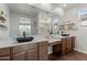 Modern bathroom with dual sinks, granite counters, a large mirror, and separate shower at 9147 W Minnezona Ave, Phoenix, AZ 85037