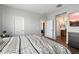 A sunlit bedroom with a decorative duvet, television, and wood-look floors at 9147 W Minnezona Ave, Phoenix, AZ 85037