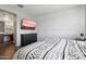 A comfortable bedroom with a decorative duvet, television, and wood-look floors at 9147 W Minnezona Ave, Phoenix, AZ 85037
