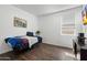 This bedroom features a large window with a street view, a bed, and wood-look floors at 9147 W Minnezona Ave, Phoenix, AZ 85037