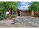 Charming single-story home with a stone facade, well-manicured landscaping, and a two-car garage at 9147 W Minnezona Ave, Phoenix, AZ 85037