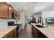 Modern kitchen with granite countertops, stainless steel appliances, and open layout to living area at 9147 W Minnezona Ave, Phoenix, AZ 85037