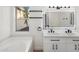 Bathroom features a double sink vanity with modern black fixtures, a bathtub and a bright window at 942 S Ash Ave # 104, Tempe, AZ 85281