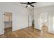 Bedroom with light wood floors, ceiling fan and doorways leading to a walk-in closet and bathroom at 942 S Ash Ave # 104, Tempe, AZ 85281