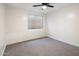 Bedroom featuring neutral carpet, neutral walls, a ceiling fan, and a large window for natural light at 942 S Ash Ave # 104, Tempe, AZ 85281