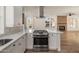 Bright, spacious kitchen featuring white cabinets, stainless steel appliances, and island with cooktop at 942 S Ash Ave # 104, Tempe, AZ 85281
