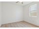 Bright bedroom features wood-look floors, ceiling fan, and window with natural light at 9510 E Theia Dr, Mesa, AZ 85212
