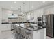 Gourmet kitchen boasts a large island, stainless steel appliances, and sleek black countertops at 9510 E Theia Dr, Mesa, AZ 85212