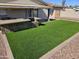 A well-maintained backyard with artificial grass, an outdoor kitchen, and a covered patio for entertaining at 9612 N 52Nd Dr, Glendale, AZ 85302