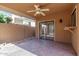 Backyard featuring a tiled patio, covered area with a ceiling fan, and a sliding glass door entrance at 1010 E Lois Ln, Phoenix, AZ 85020