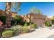 A single-story home with a two-car garage, showcasing mature trees and flowering shrubs for added curb appeal at 1010 E Lois Ln, Phoenix, AZ 85020