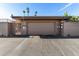 Spacious garage with a secure gate, complemented by brick accents and desert landscaping at 10802 W Thunderbird Blvd, Sun City, AZ 85351