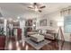 Open-concept living room featuring a comfortable couch, hardwood floors, and seamless access to the kitchen at 10811 W Avenida Del Rey --, Peoria, AZ 85383
