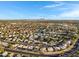High-angle aerial shot showcasing a neighborhood with diverse housing, manicured lawns, and curved streets under a bright sky at 1120 E Harbor View Dr, Gilbert, AZ 85234