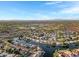 Aerial view showcases a scenic neighborhood with water features, baseball fields, and mature greenery under a vast sky at 1120 E Harbor View Dr, Gilbert, AZ 85234