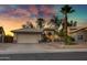 Inviting single-story home featuring desert landscaping, an attached two-car garage, and a captivating sunset at 1120 E Harbor View Dr, Gilbert, AZ 85234