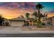 Inviting single-story home featuring desert landscaping, an attached two-car garage, and a captivating sunset at 1120 E Harbor View Dr, Gilbert, AZ 85234