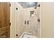 Bathroom shower features a glass door, tiled walls, and built-in shelving at 11398 E Desert Vista Rd, Scottsdale, AZ 85255