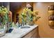 Features a unique bathroom vanity with stone countertop and beautiful floral accents, offering a luxurious feel at 11398 E Desert Vista Rd, Scottsdale, AZ 85255