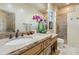 Bathroom featuring double sinks, stone counter tops, decorative plants, and natural light at 11398 E Desert Vista Rd, Scottsdale, AZ 85255