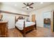 This bedroom boasts hardwood floors, a ceiling fan, and a detailed wooden bed frame at 11398 E Desert Vista Rd, Scottsdale, AZ 85255
