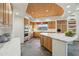 The kitchen boasts custom cabinets, a curved island with stone countertops and high-end appliances at 11398 E Desert Vista Rd, Scottsdale, AZ 85255