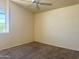 A neutral-toned bedroom with a ceiling fan and a large window at 11403 W Rosewood Dr, Avondale, AZ 85392