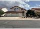 Charming two-story home with a three-car garage, arched entry, well-maintained landscaping, and a red tile roof at 11403 W Rosewood Dr, Avondale, AZ 85392