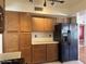 Functional kitchen featuring wood-look cabinets, black appliances, and ample storage space at 11403 W Rosewood Dr, Avondale, AZ 85392