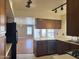 Well-lit kitchen featuring wood-look cabinets, white countertops, black appliances, and a view into the adjacent dining area at 11403 W Rosewood Dr, Avondale, AZ 85392