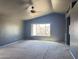 Spacious living room with vaulted ceiling, ceiling fan, carpet flooring, and a large window view at 11403 W Rosewood Dr, Avondale, AZ 85392