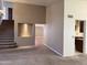 Open living room with staircase, and view into kitchen and another room with wood floors at 11403 W Rosewood Dr, Avondale, AZ 85392
