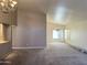 Open-concept living area featuring neutral walls, carpet, and an elegant chandelier over the dining space at 11403 W Rosewood Dr, Avondale, AZ 85392
