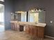 Bathroom with double vanity, sinks, vanity mirrors, and dark paint at 11403 W Rosewood Dr, Avondale, AZ 85392