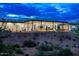 Modern, desert home with a flat roof, desert landscaping, and large sliding glass doors at 11426 E Quail Ln, Cave Creek, AZ 85331