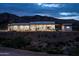 Modern desert home at twilight, featuring a sleek design with large windows and natural landscaping at 11426 E Quail Ln, Cave Creek, AZ 85331