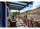 Inviting patio with pergola, retaining wall, and desert landscape, perfect for enjoying the outdoors at 11426 E Quail Ln, Cave Creek, AZ 85331