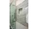 Modern shower with gray tiling, built-in niche, and a frameless glass door for a sleek and luxurious experience at 11426 E Quail Ln, Cave Creek, AZ 85331