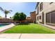 Serene backyard with artificial grass, mature tree, and access to the swimming pool at 11455 E Persimmon Ave, Mesa, AZ 85212