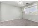 Bedroom with neutral carpet, a ceiling fan, a large window, and built-in shelving at 11455 E Persimmon Ave, Mesa, AZ 85212