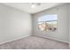 Bedroom with neutral carpet, ceiling fan, and a large arched window overlooking the neighborhood at 11455 E Persimmon Ave, Mesa, AZ 85212