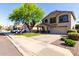 Two-story home with a spacious driveway, mature tree, and low-maintenance desert landscaping at 11455 E Persimmon Ave, Mesa, AZ 85212