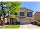 Inviting two-story home featuring desert landscaping, mature tree, covered porch and a two car garage at 11455 E Persimmon Ave, Mesa, AZ 85212
